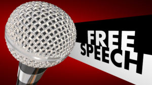 Free Speech words beside a 3d microphone to symbolize the first amendment and freedom of expression