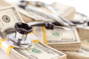 Stethoscope Laying on Stacks of Hundred Dollar Bills with Narrow Depth of Field.
